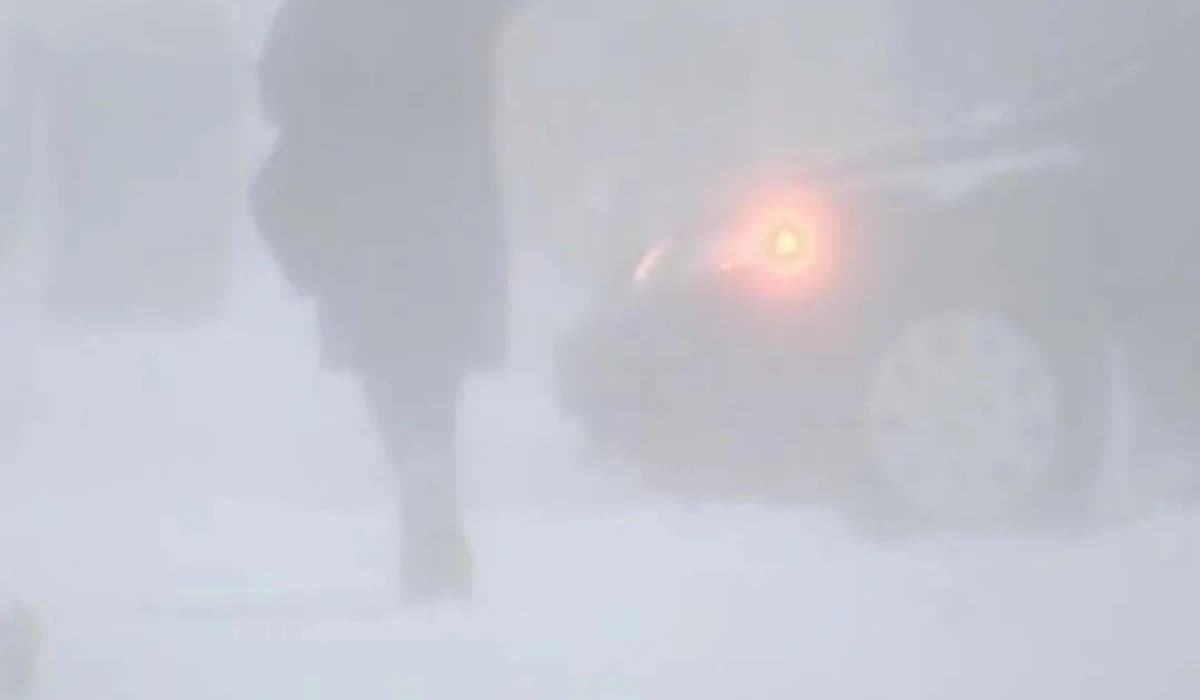 Snow-covered highway in Northern Manitoba during an intense blizzard warning with strong winds and low visibility.